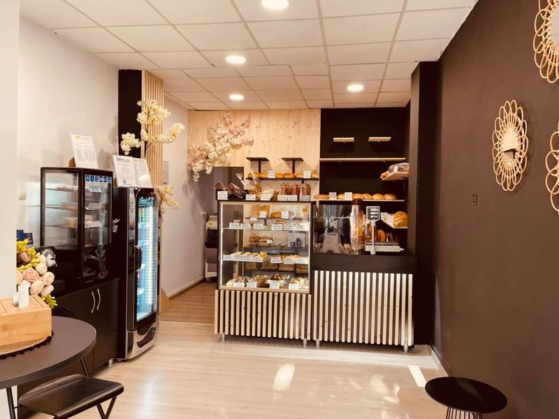 Interiorul magazinului Pandipo Gara: vitrina cu produse de patiserie, rafturi cu pâine și frigidere cu băuturi